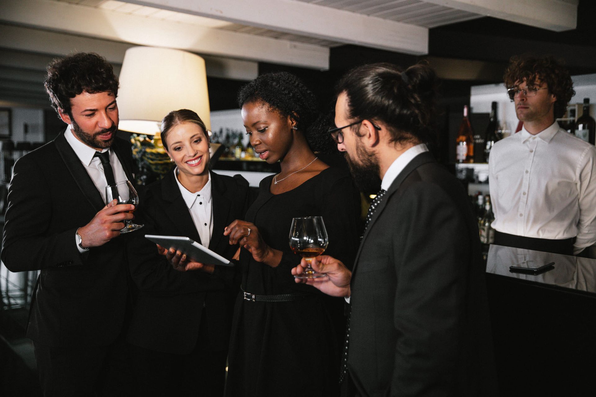 A Group of People Are Standing Around a Table in a Restaurant — Kansas City, MO — SD Smith Business Resource Consulting Firm