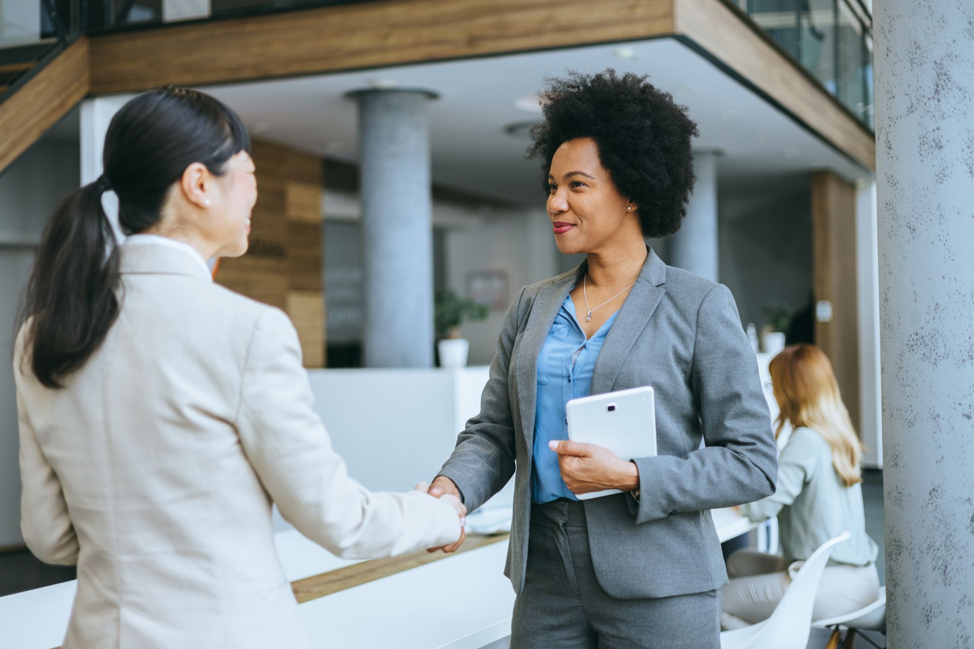 Two Women Are Shaking Hands in an Office — Kansas City, MO — SD Smith Business Resource Consulting Firm