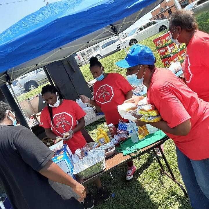 A Group of People Are Standing around a Table Under a Tent — Kansas City, MO — SD Smith Business Resource Consulting Firm