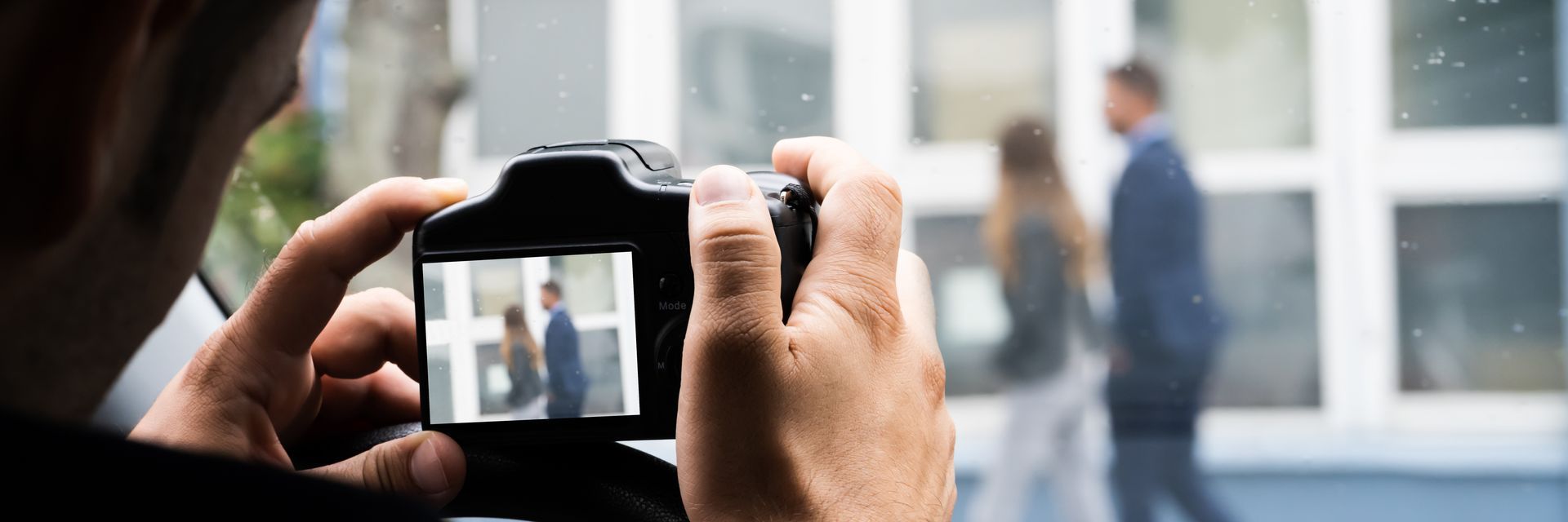 A person holding a baby up in the air indoors near a window, baby smiling.