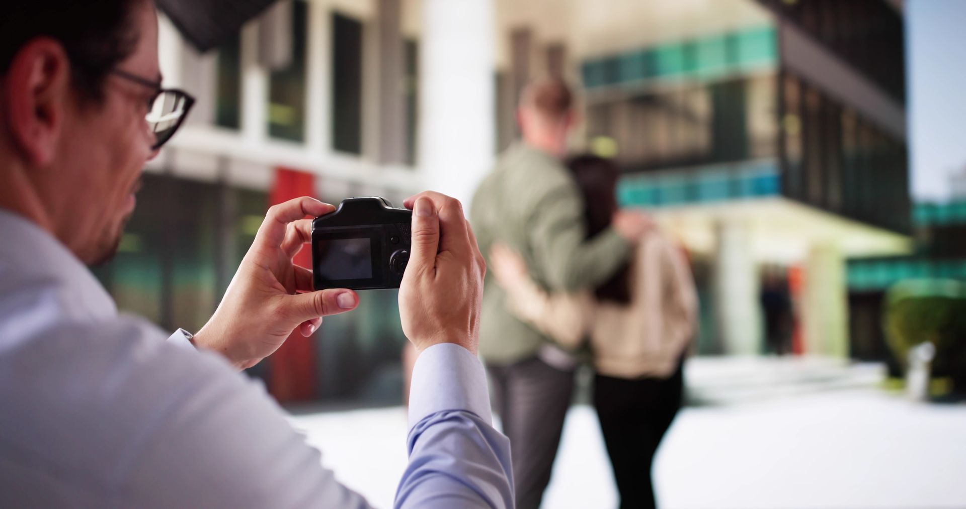 Woman in straw hat smiles, holding wine glass near a lake.