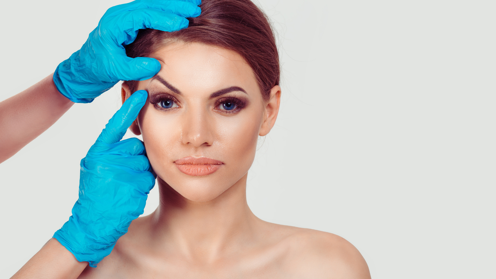 Doctor with gloves pointing at woman's eyebrows for PDO thread lift consultation