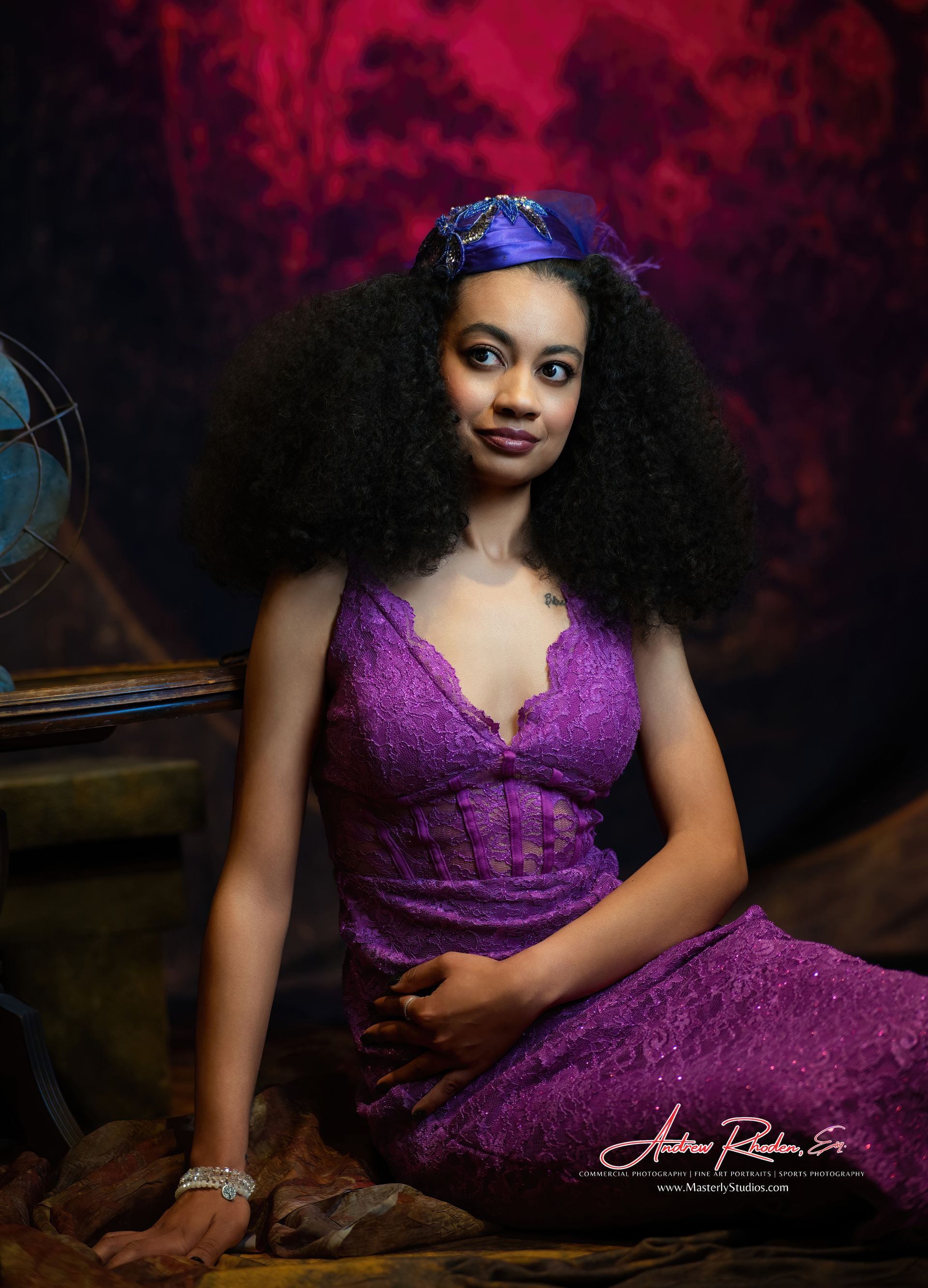 Woman in purple sequin dress with large afro, leaning, looking at viewer.