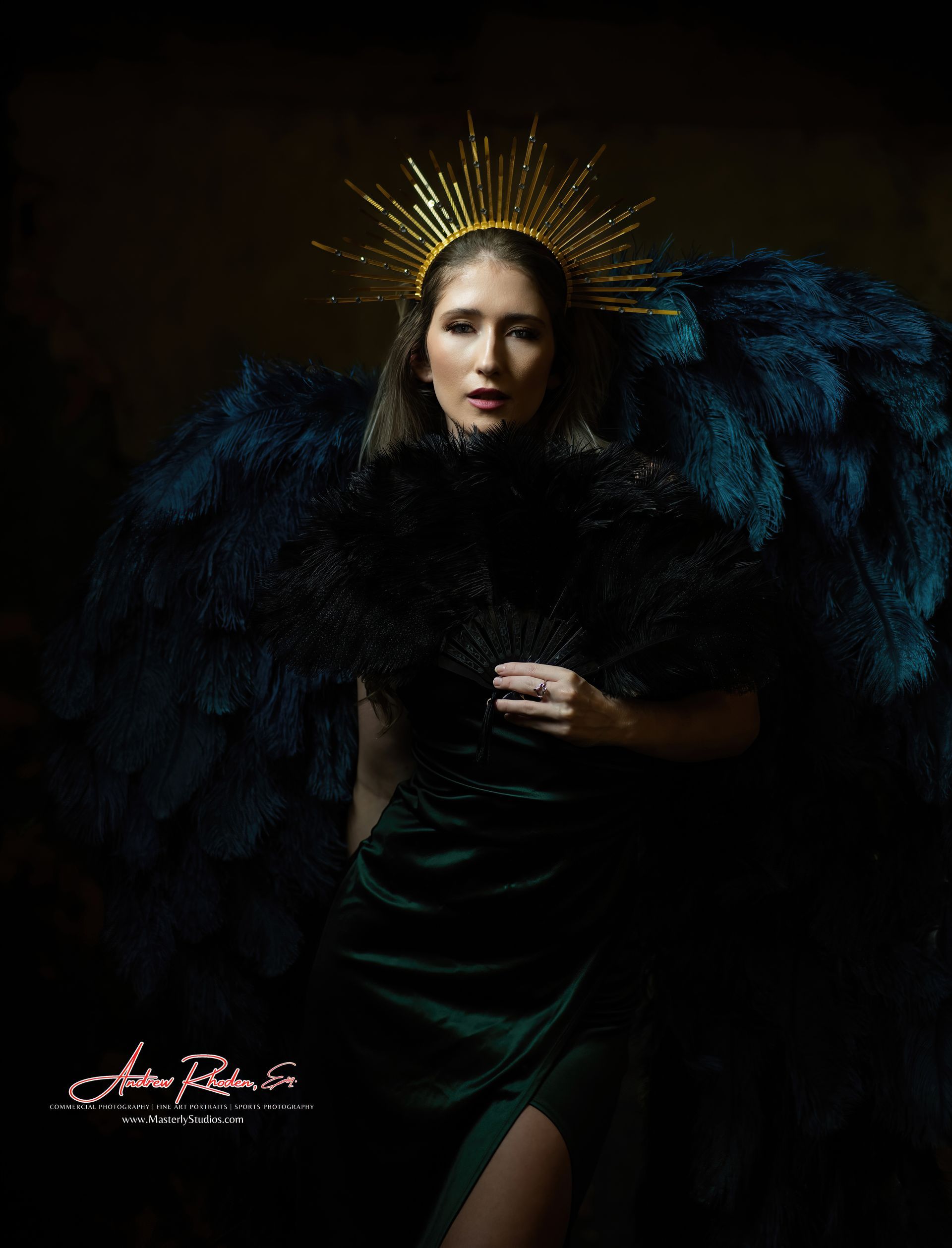 Woman in dark emerald dress and feathered wings, wearing gold halo.