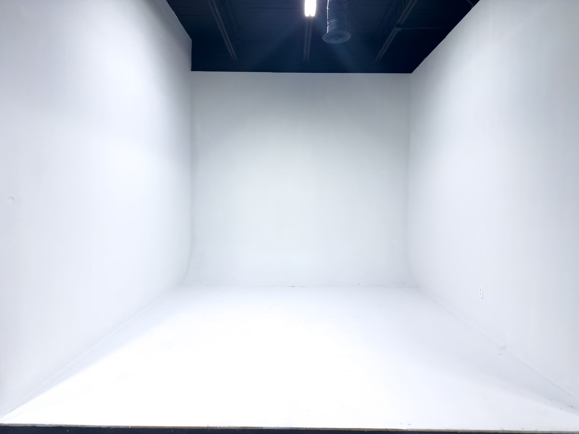Woman in fitness attire doing a side plank, arm raised, in studio with white backdrop.
