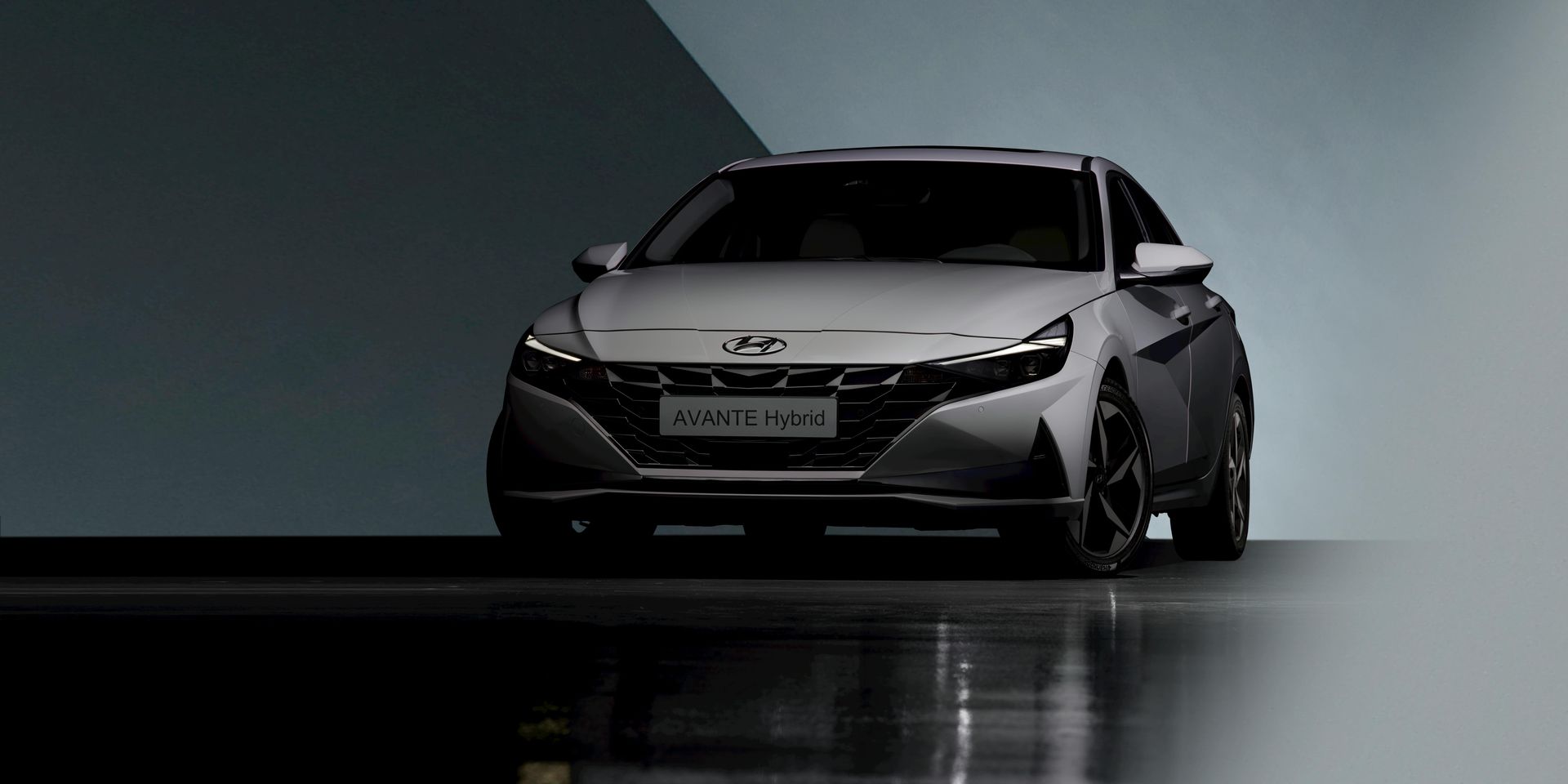 A gray Hyundai Elantra sedan against a backdrop of gray and blue walls.