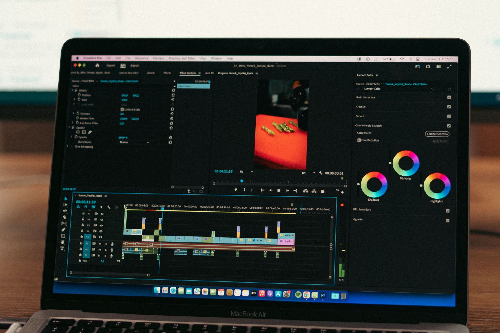 Photo editing software open on a laptop screen with a dark interface and colorful adjustment panels