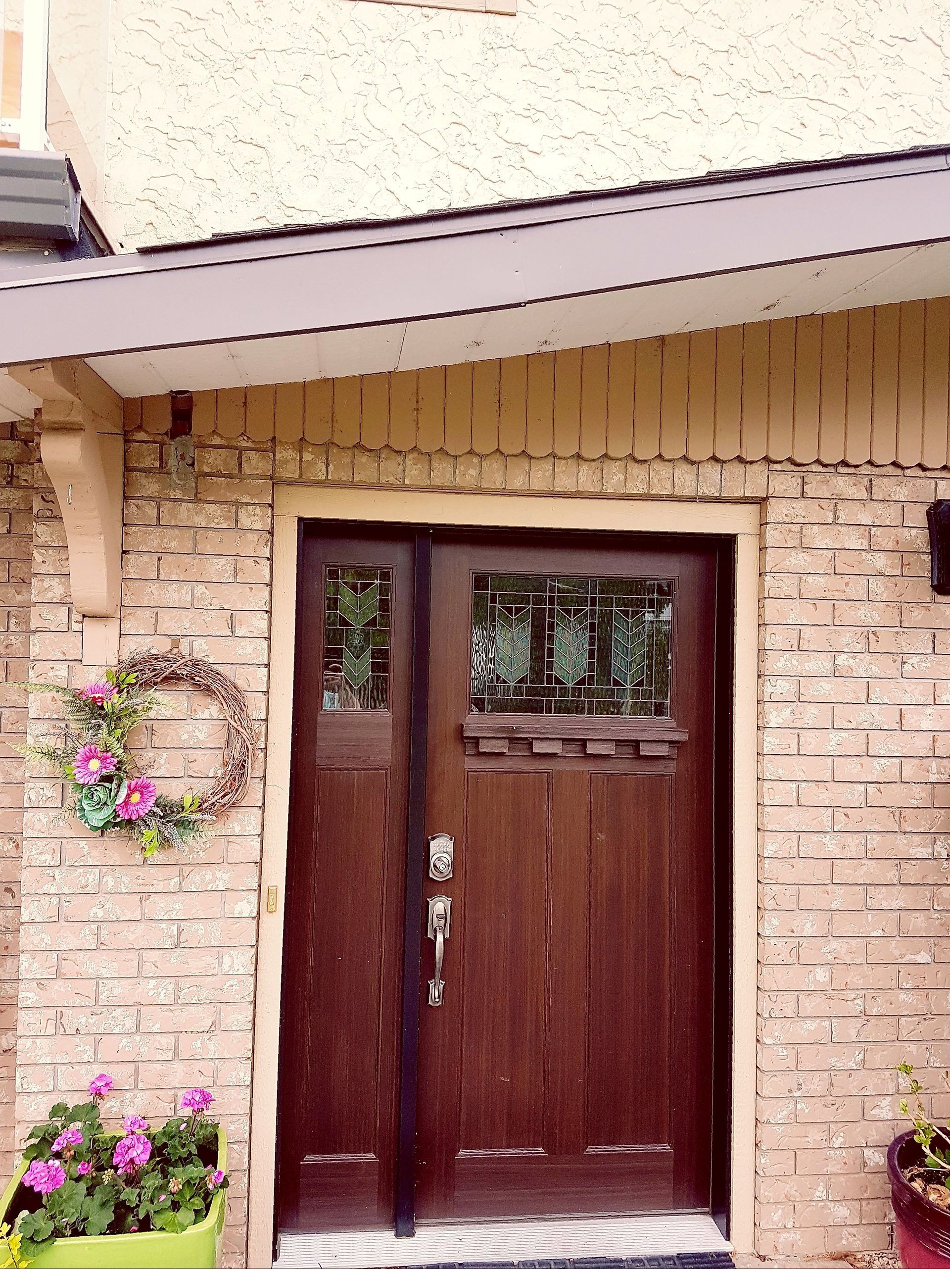 The front door of a brick house with a wooden door