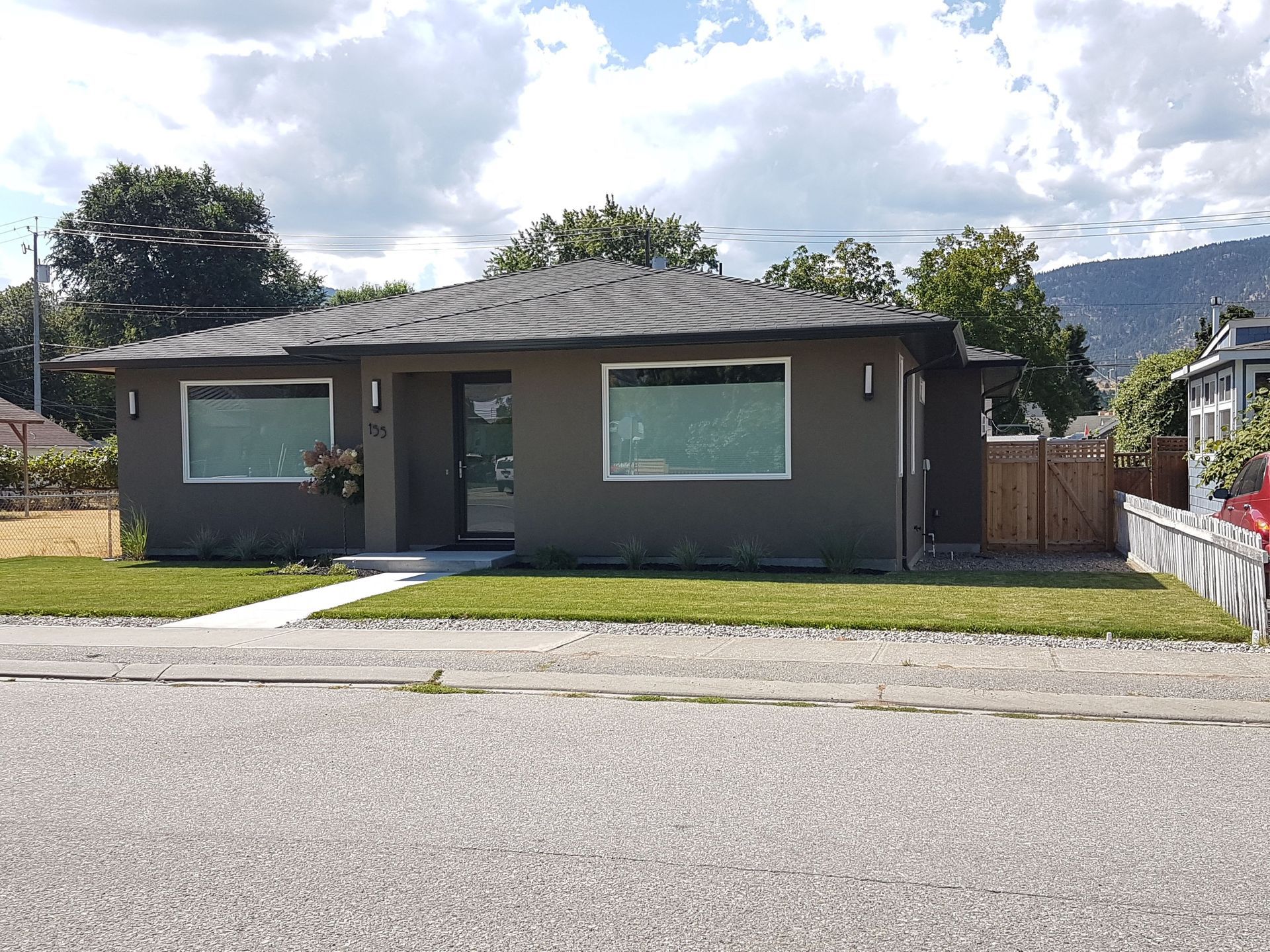 A house with a lot of windows and a fence in front of it.