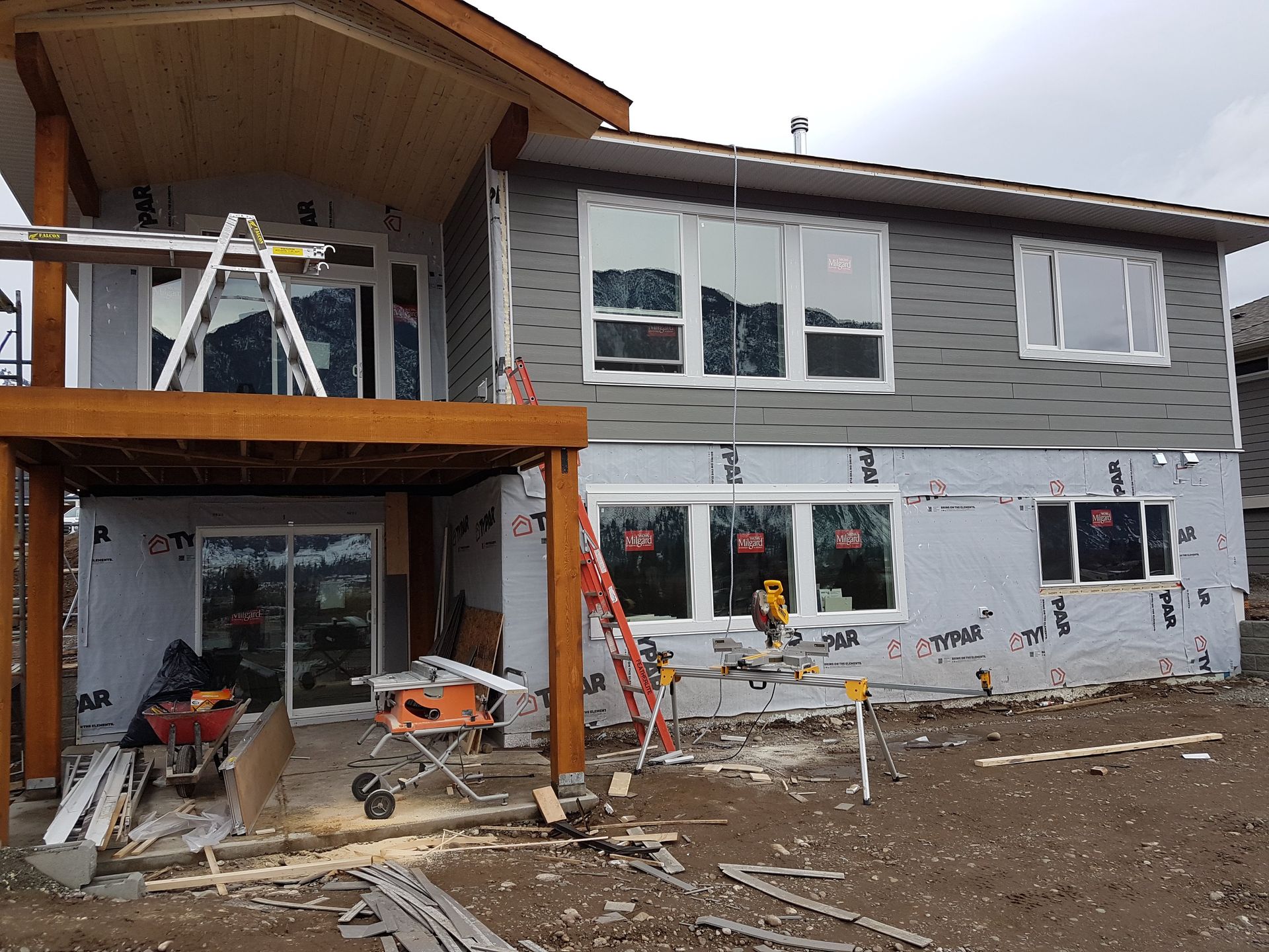 A house is being built with a lot of windows and a deck.