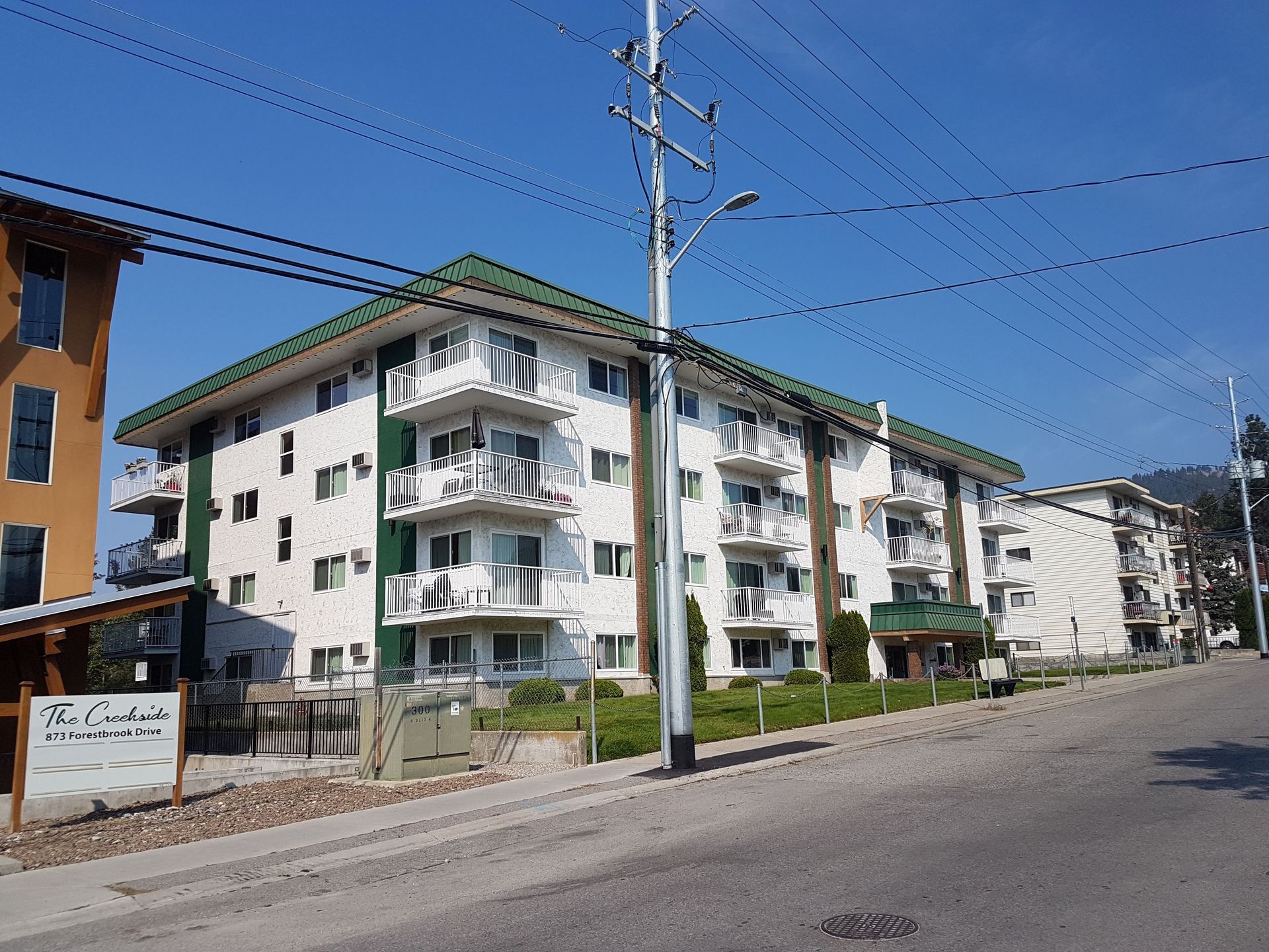A large apartment building with a green roof and balconies