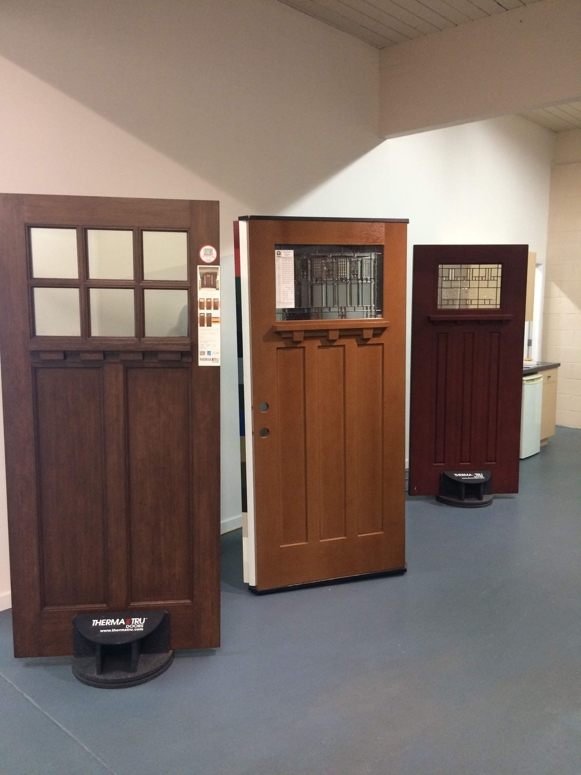 Three different types of doors are lined up in a room