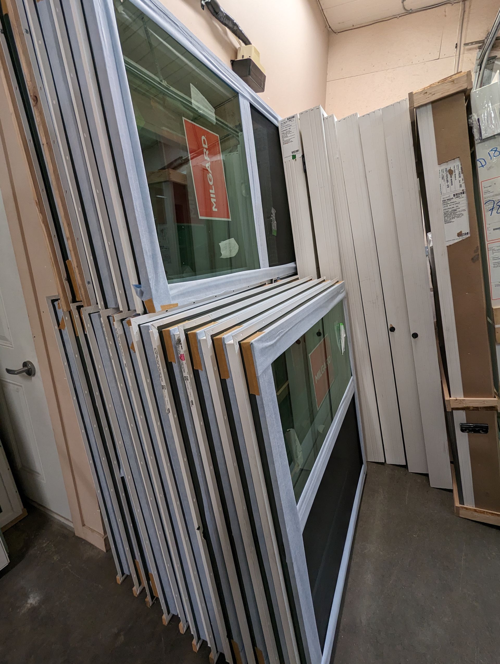 A bunch of windows are stacked on top of each other in a room.