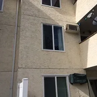 A building with a lot of windows and an air conditioner on the side of it.