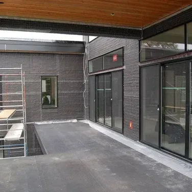 A building under construction with a lot of windows and sliding glass doors.