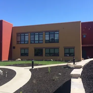 A large building with a lot of windows and a walkway leading to it