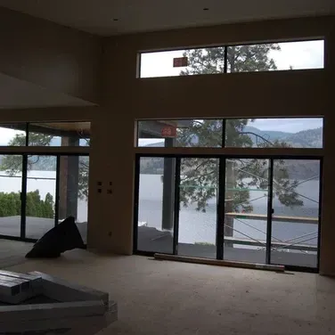 A large room with lots of windows and a view of a lake