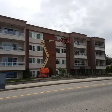 A large apartment building with a crane on the side of it