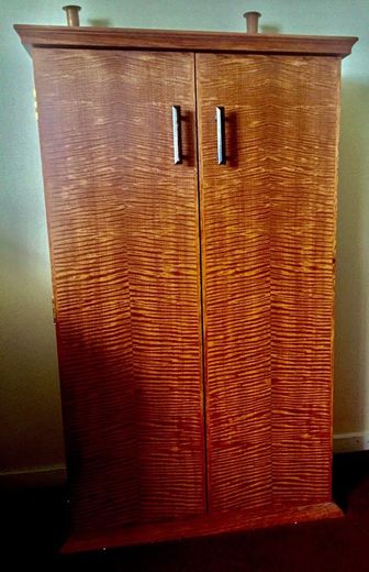 A wooden cabinet with two doors is sitting in a room.