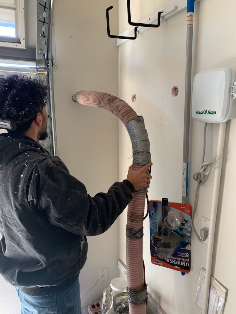 A man is holding a hose in a room.