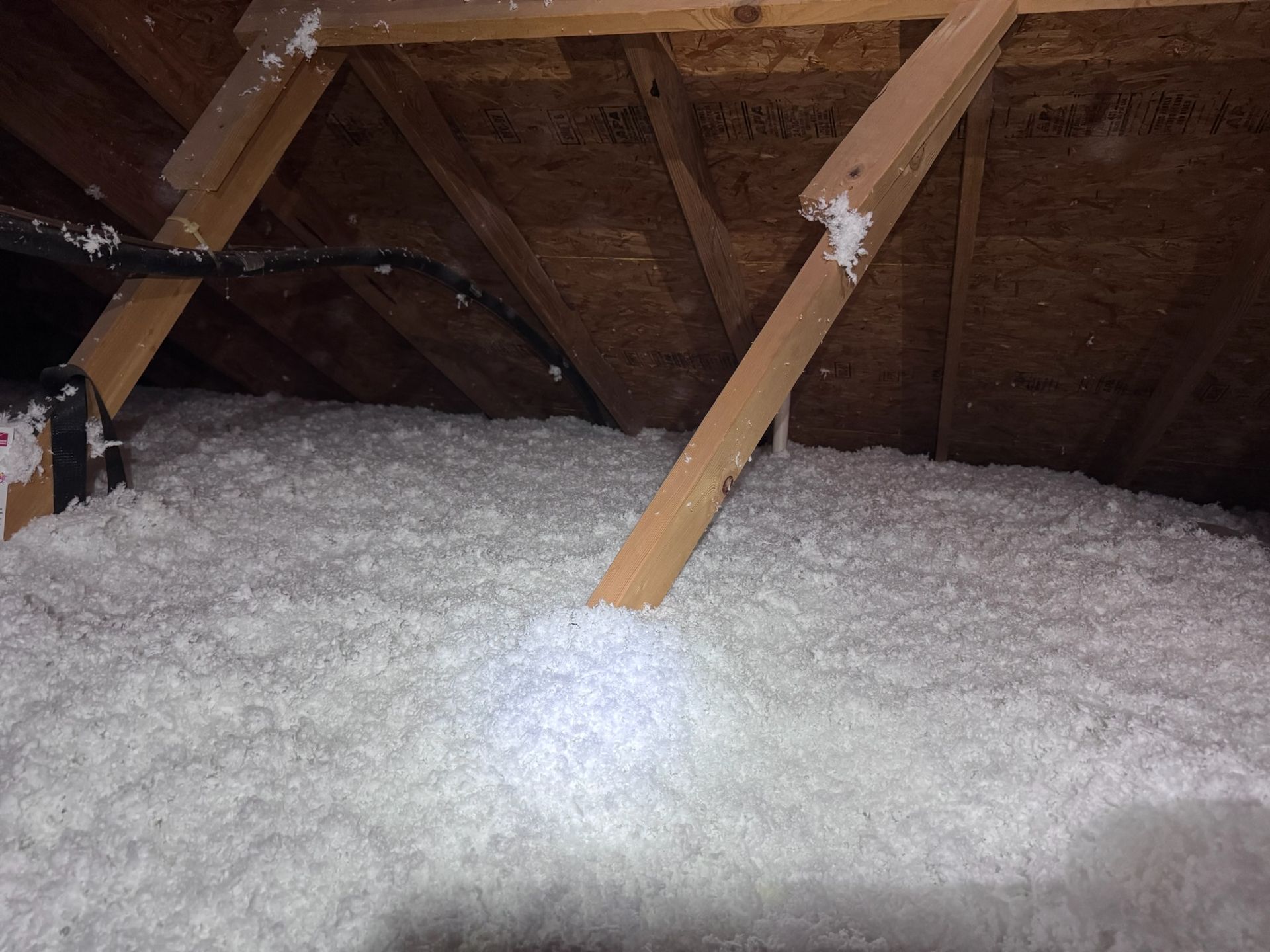 There is a lot of insulation in the attic of a house.