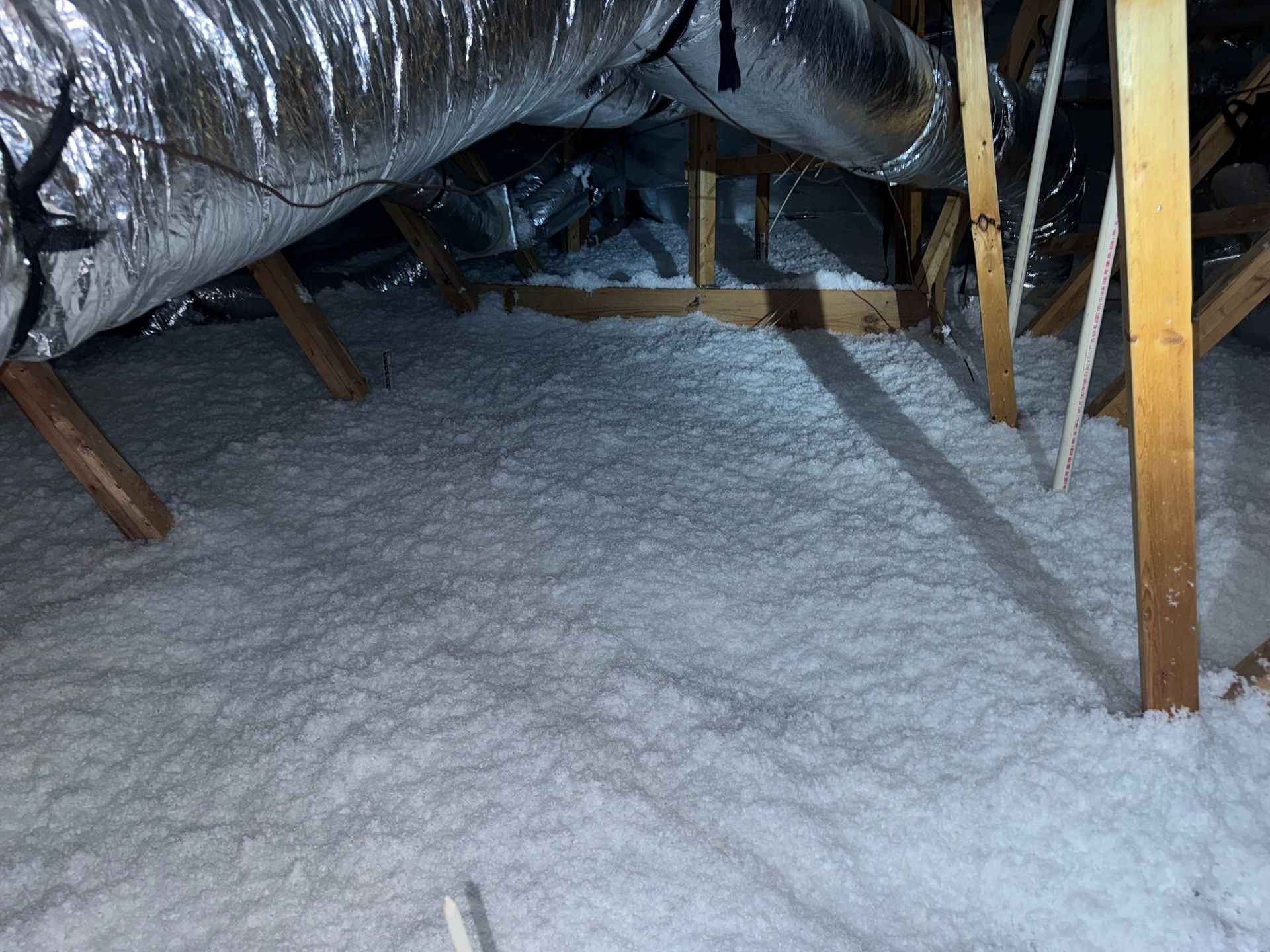 There is a lot of insulation in the attic of a house.