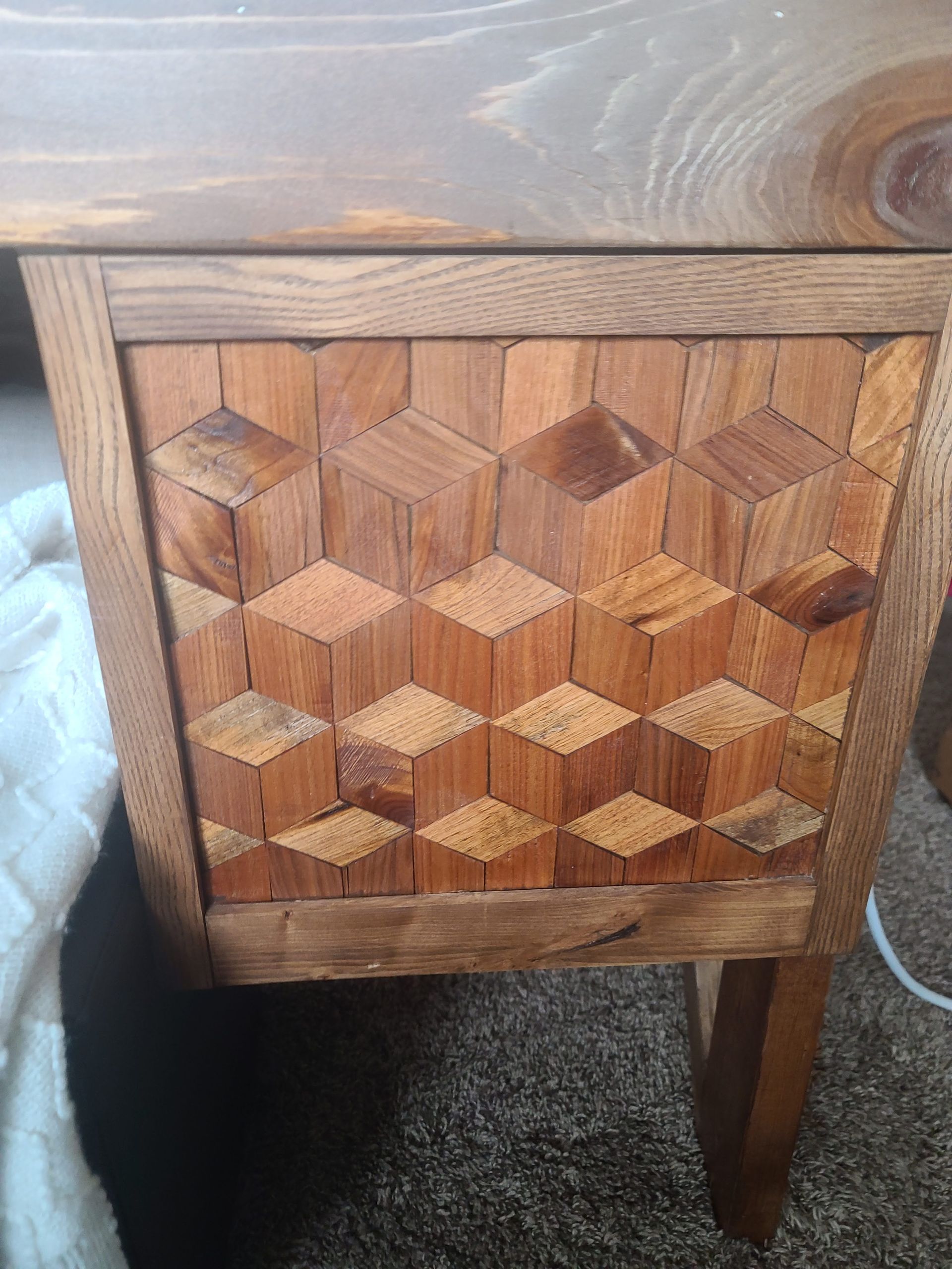 Wooden desk drawer with a geometric, three-dimensional cube pattern.