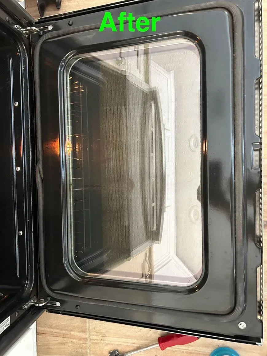 A clean oven door, showing a clear glass window and a black frame, labeled with the word 