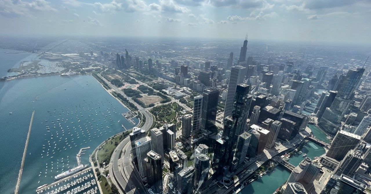 Aerial view of Chicago skyline, buildings along blue Lake Michigan, boats, and park.