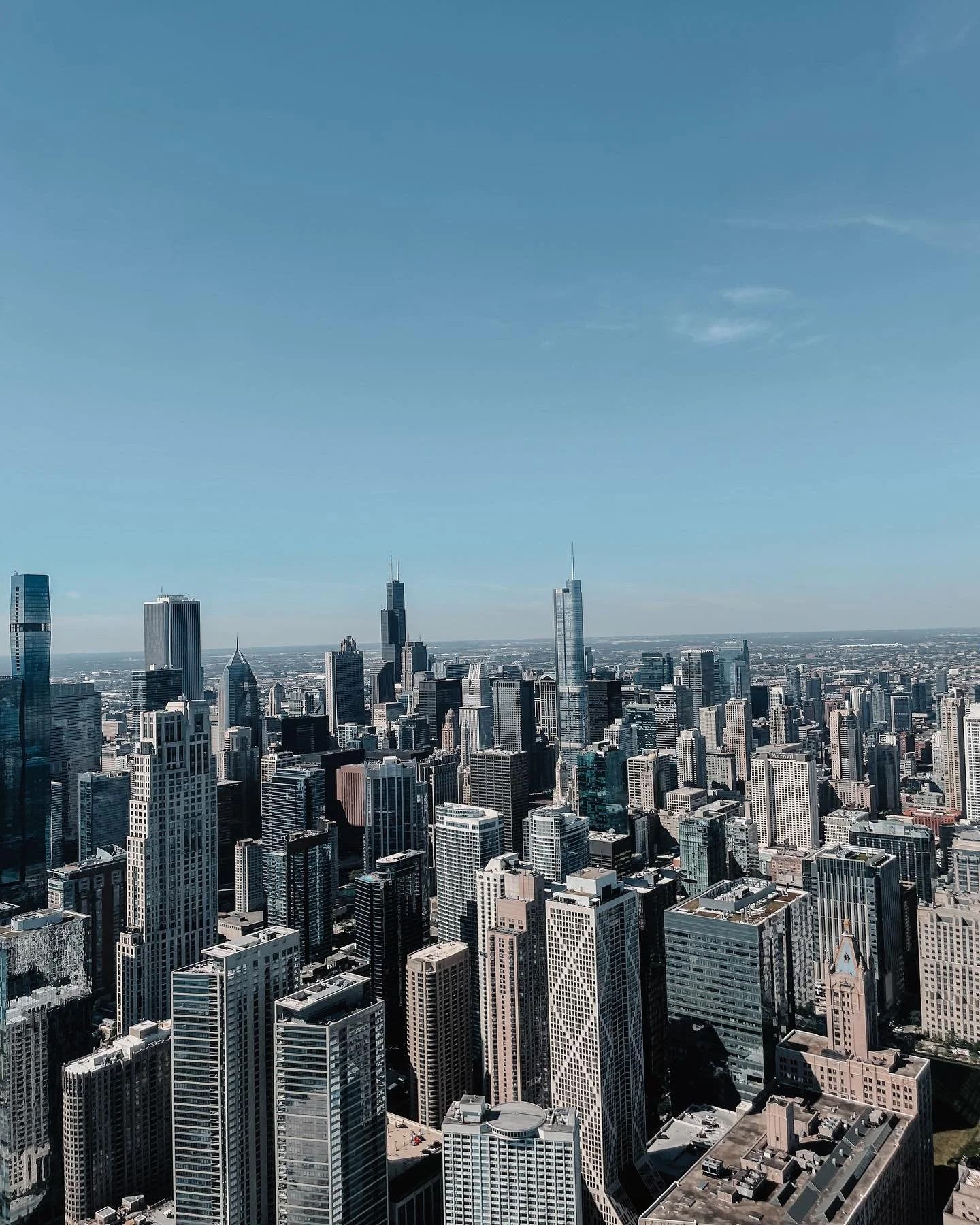 City skyline under a clear blue sky, buildings of various heights and architectural styles.