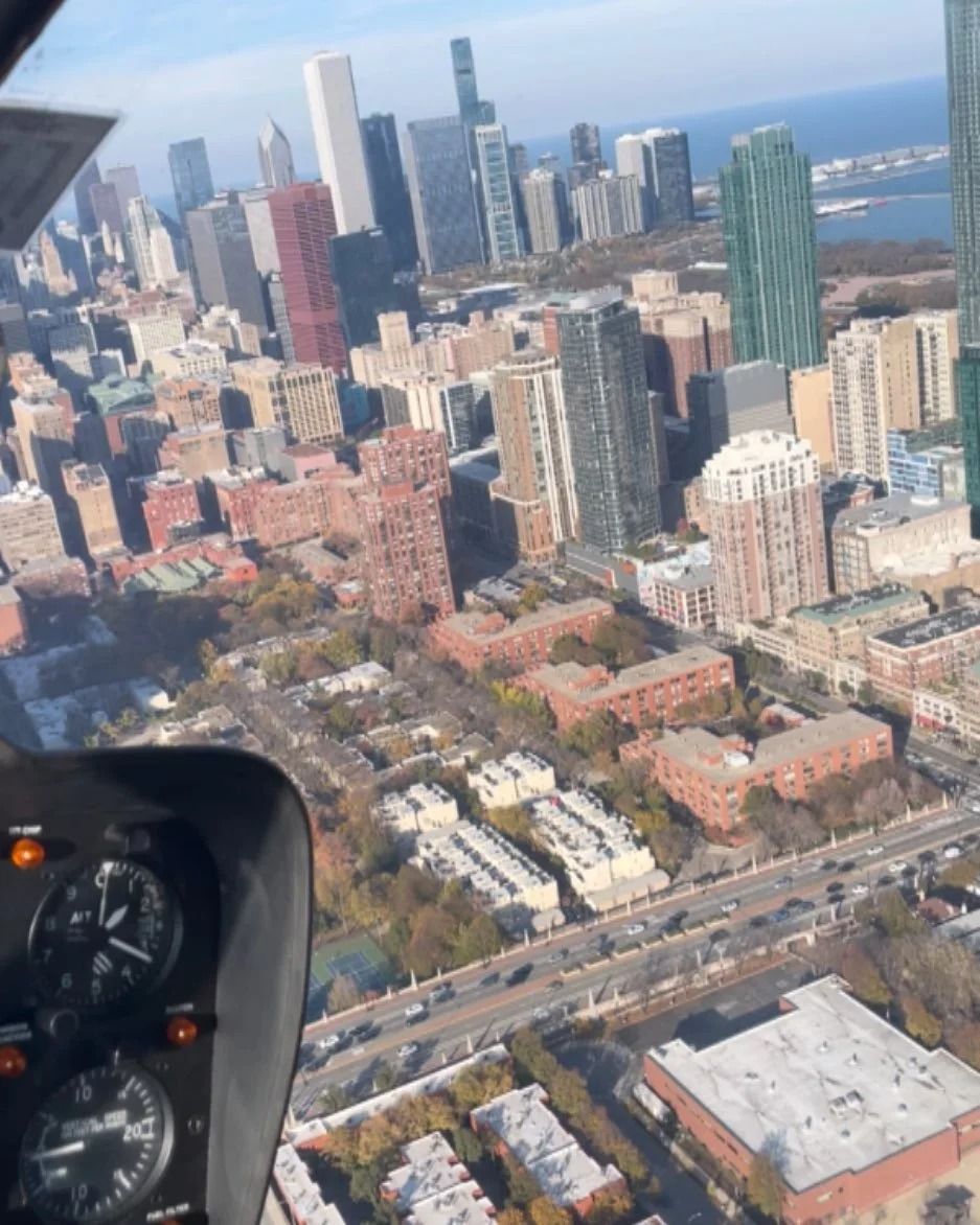Aerial view of Chicago cityscape with buildings, Lake Michigan, from a helicopter cockpit.