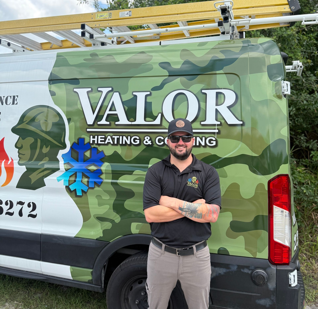 Man standing in front of a camo Valor Heating & Cooling van with a ladder on top