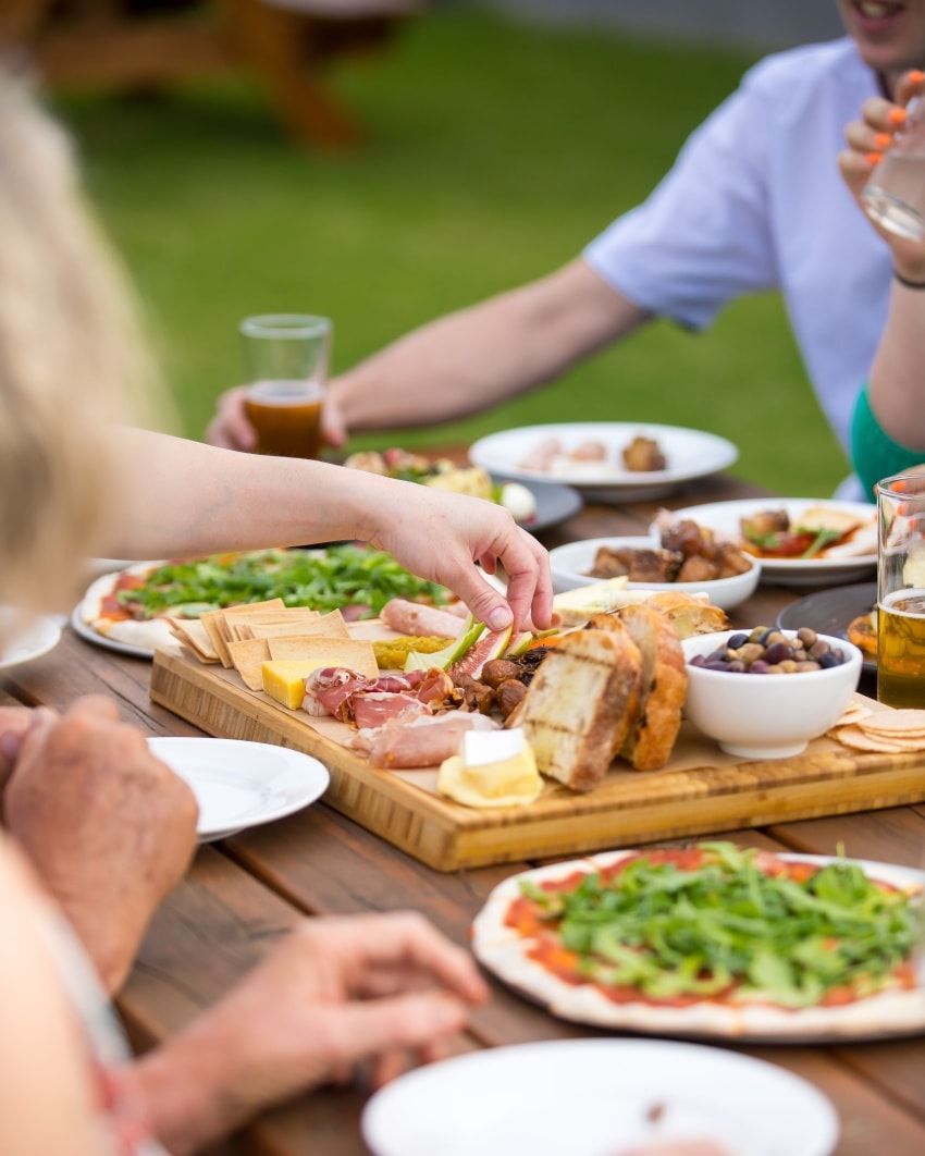 A Group of People Are Sitting at a Table Eating Food — Monty Brewing Co. In Highfields, QLD
