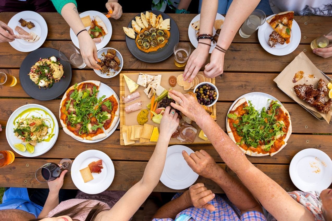 A Group of People Are Sitting at a Table Eating Food — Monty Brewing Co. In Highfields, QLD