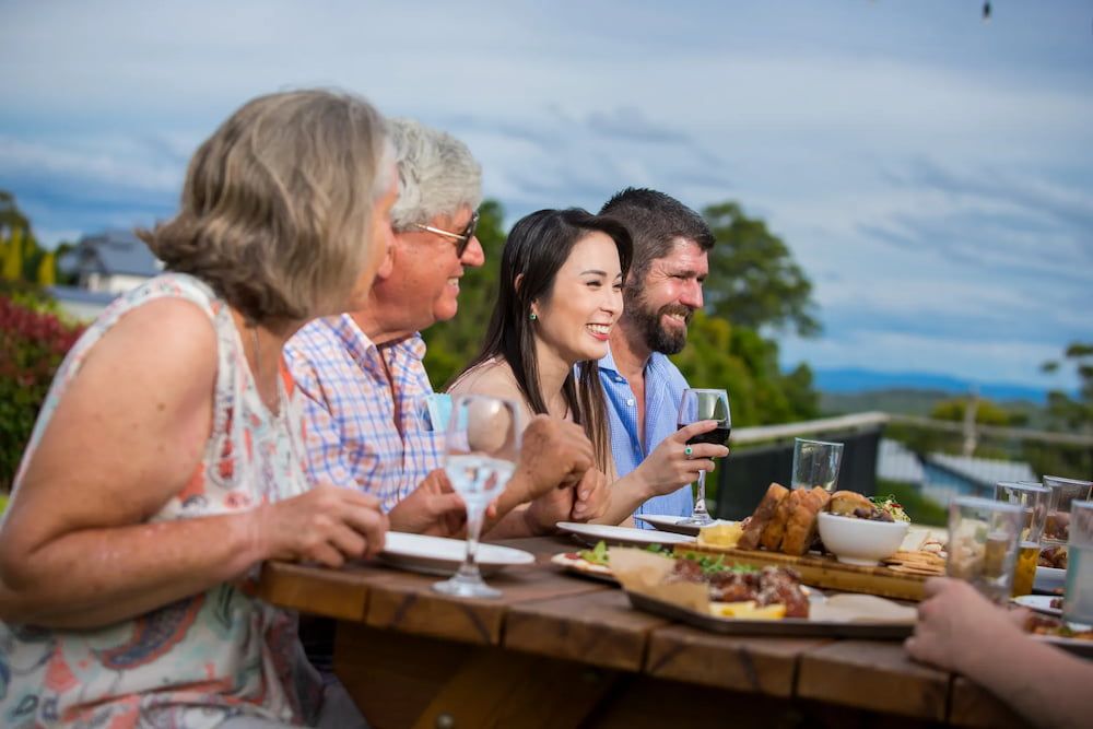 A Group of People Are Sitting at a Table Eating Food and Drinking Wine — Monty Brewing Co. In Highfields, QLD
