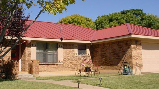 Roof Repair — Brick House with Red Roof in San Antonio, TX