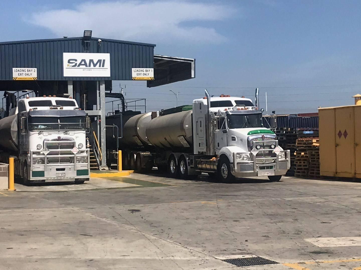 Two Semi Trucks Are Parked In Front Of A Building — Willow's Bitumen Haulage Pty Ltd In New South Wales
