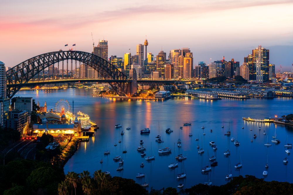 A Bridge Over A Body Of Water With Boats And A City In The Background - Willow's Bitumen Haulage Pty Ltd In Queensland
