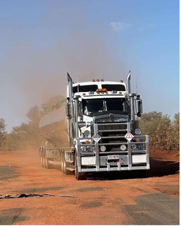 A Mack Semi Truck Is Driving Down A Road — Willow's Bitumen Haulage Pty Ltd In Stuart, QLD