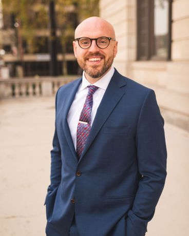 A man with a beard is wearing a suit and tie.
