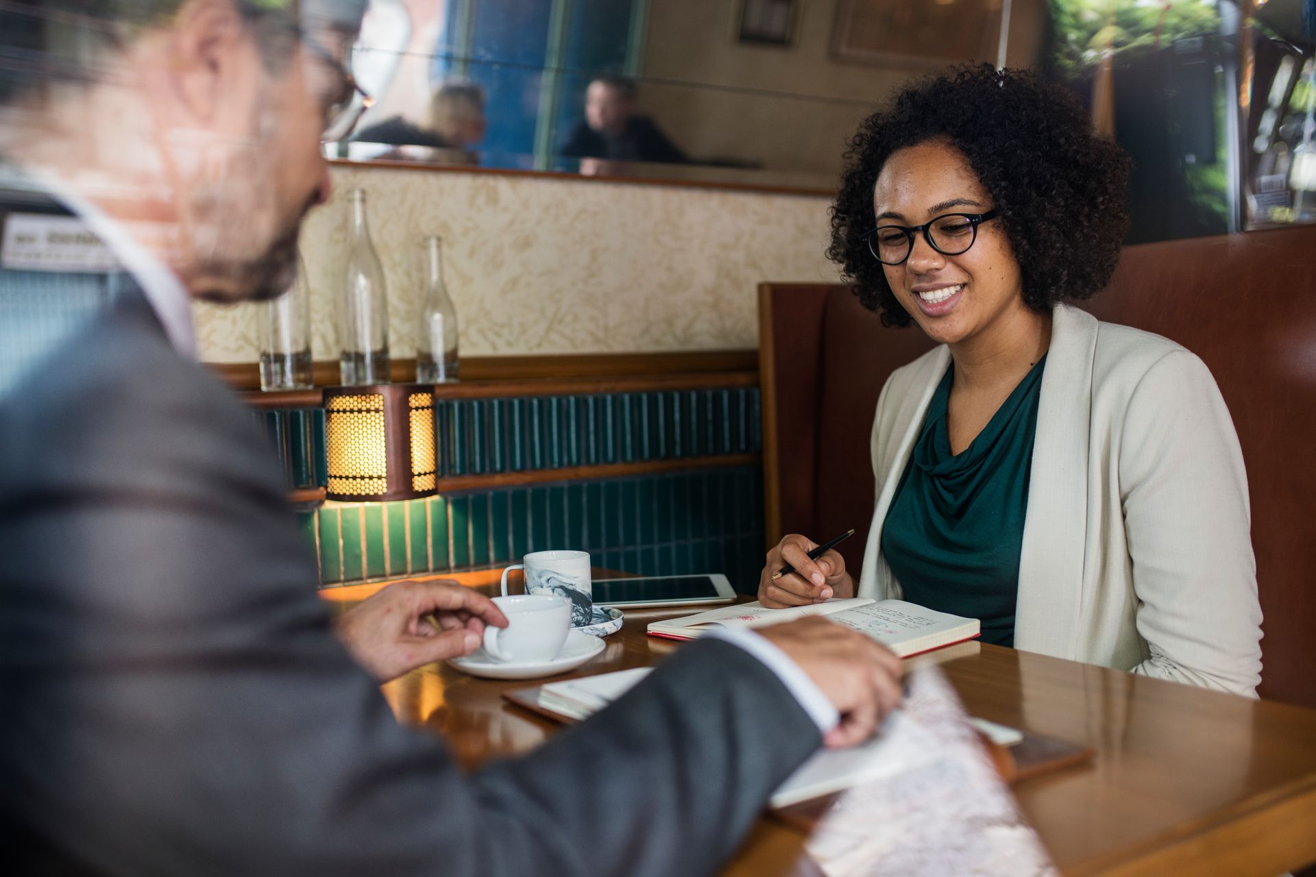 A man and a woman are sitting at a table in a restaurant having a conversation.