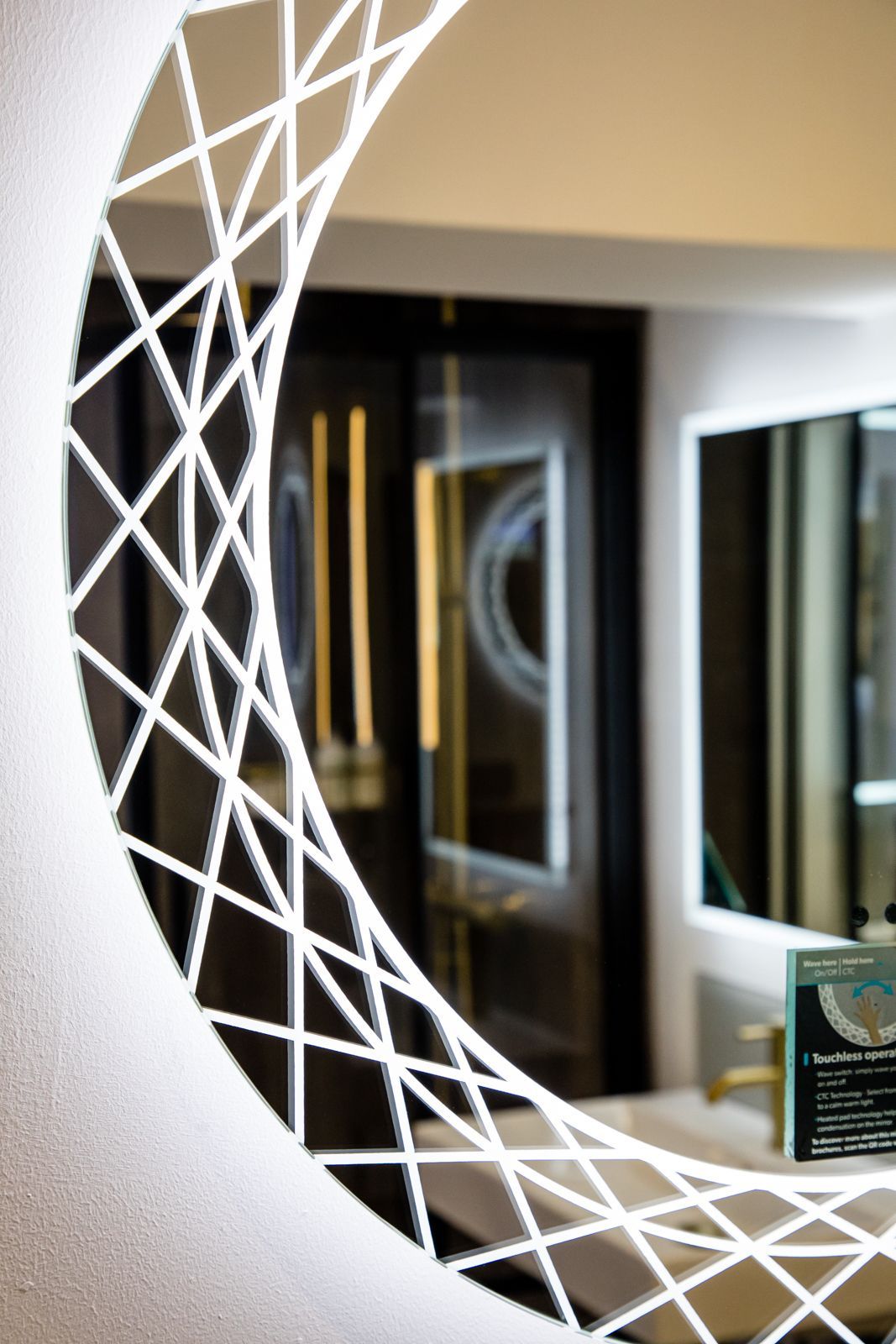 A bathroom with a circular mirror and a sink