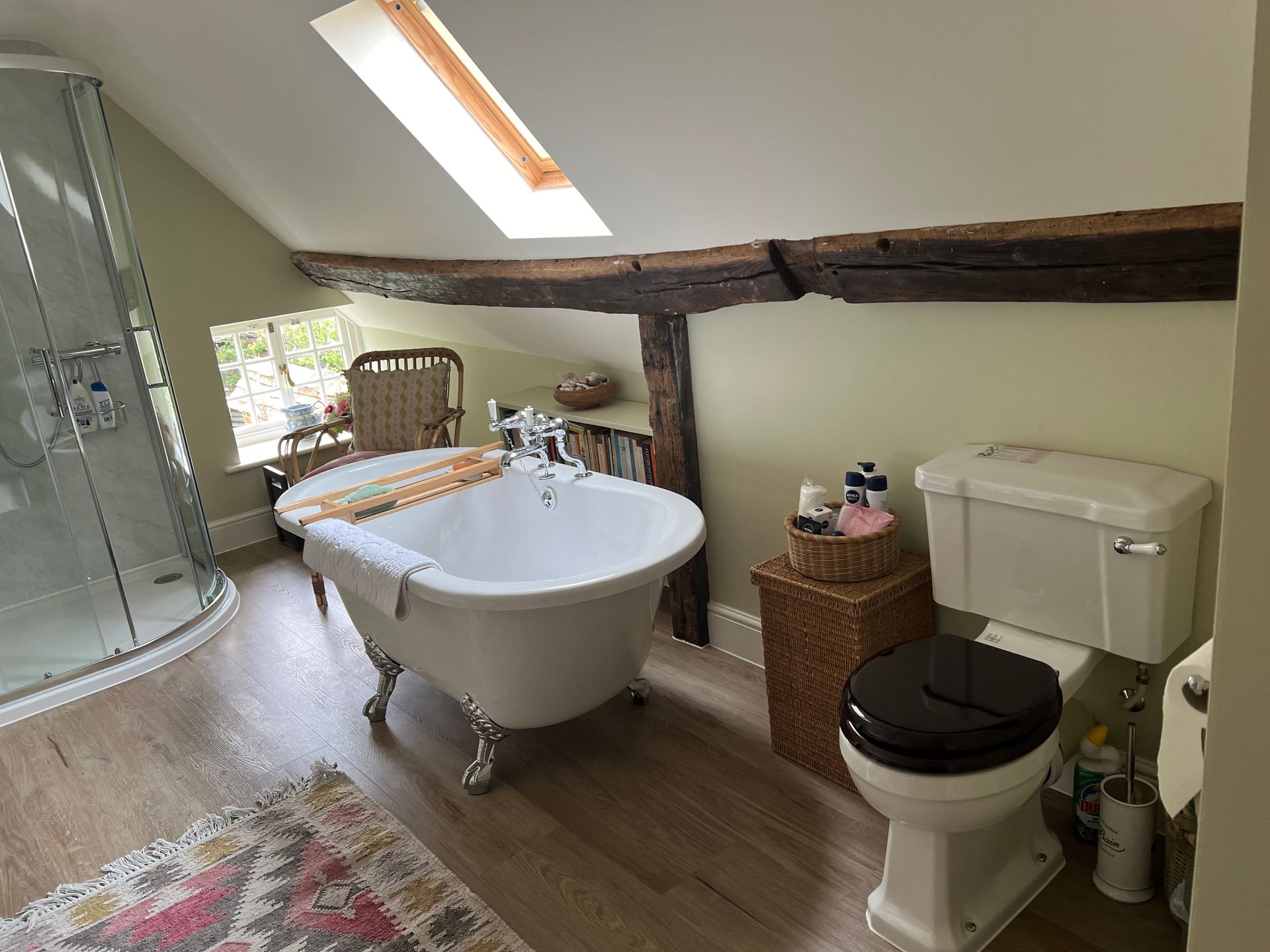 A bathroom with a bathtub , toilet and shower.