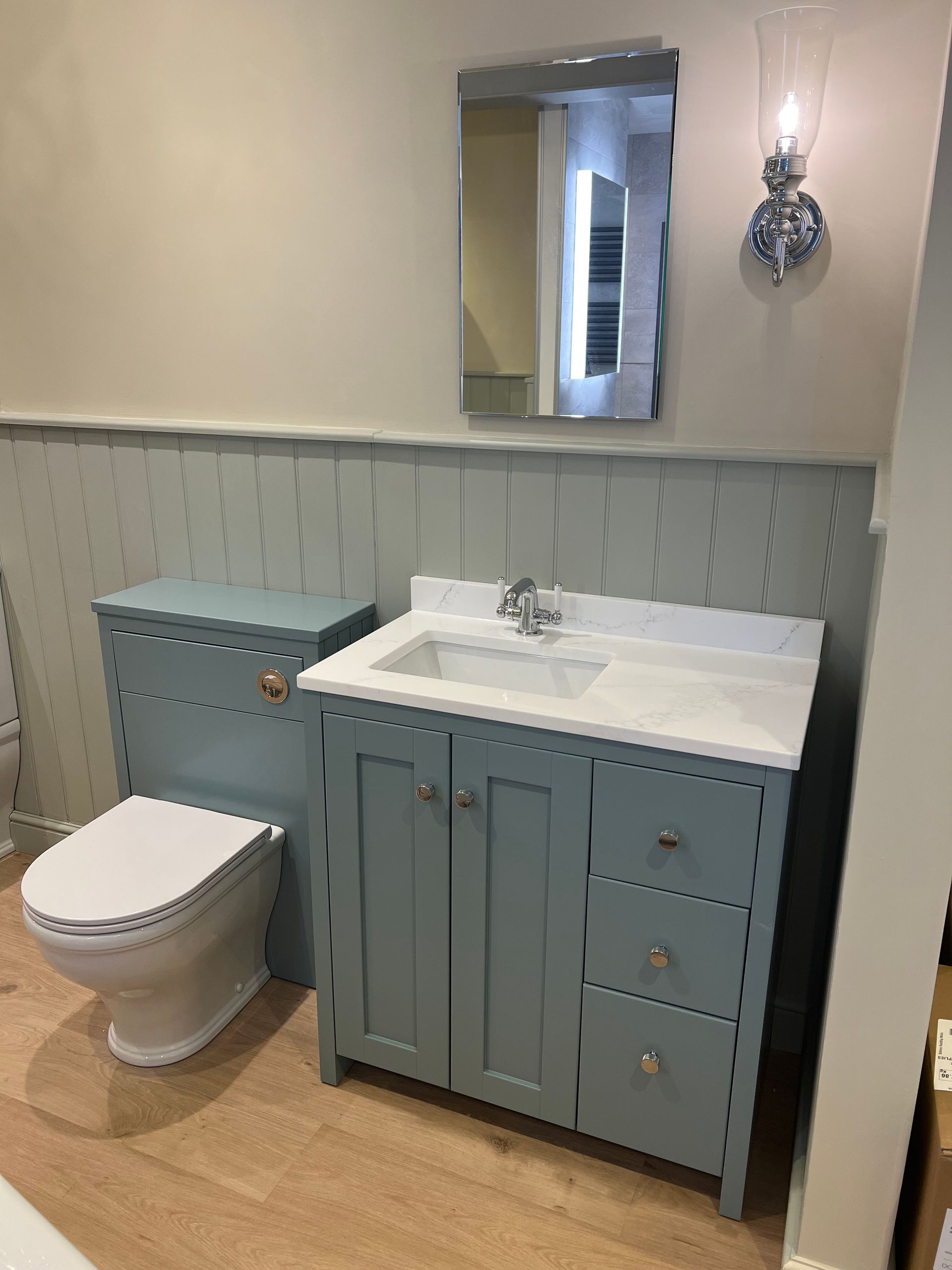 A bathroom with a sink , toilet and mirror.
