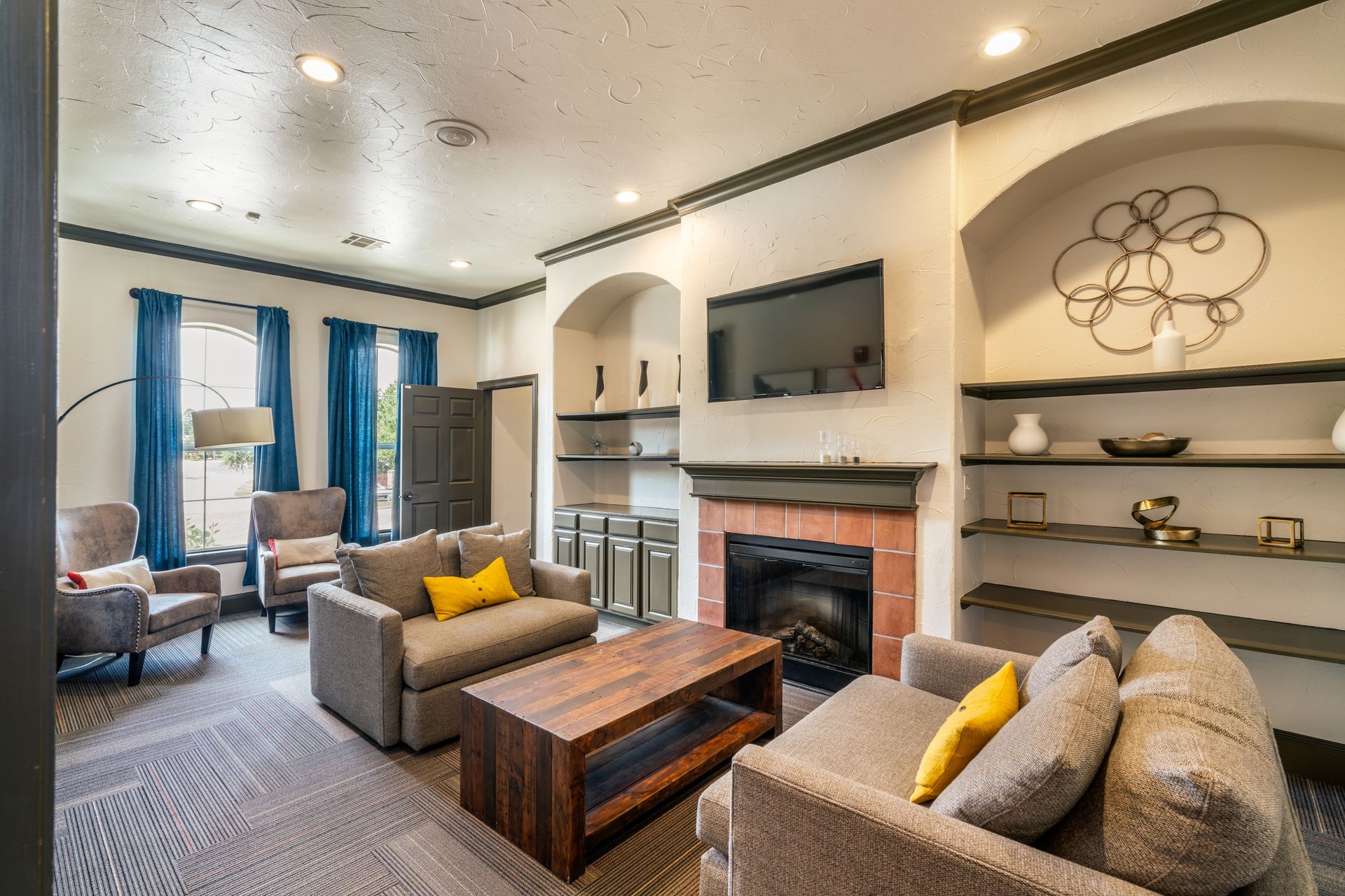 Living room with gray couches, fireplace, and built-in shelves.