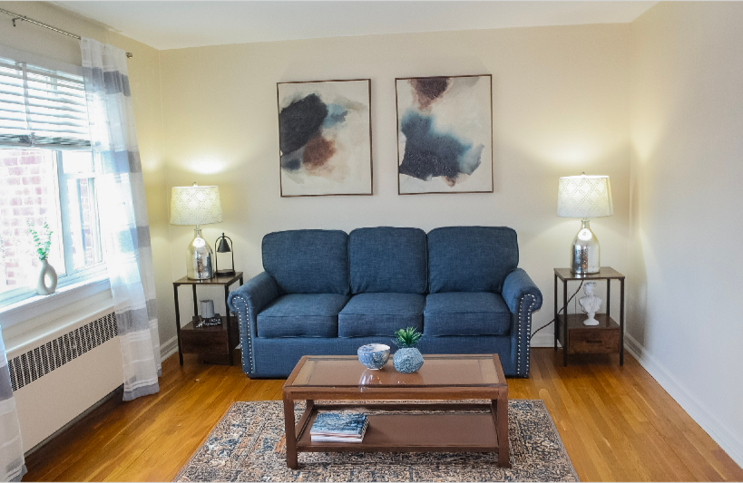 A living room with a blue couch and a coffee table