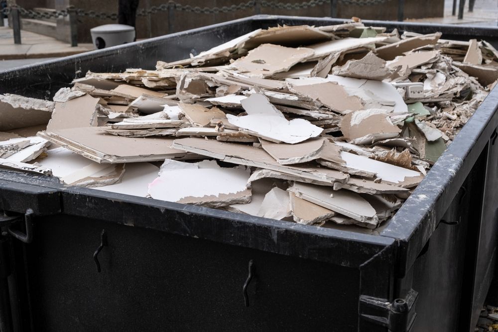 Overflowing dumpster filled with torn cardboard and packing debris outdoors