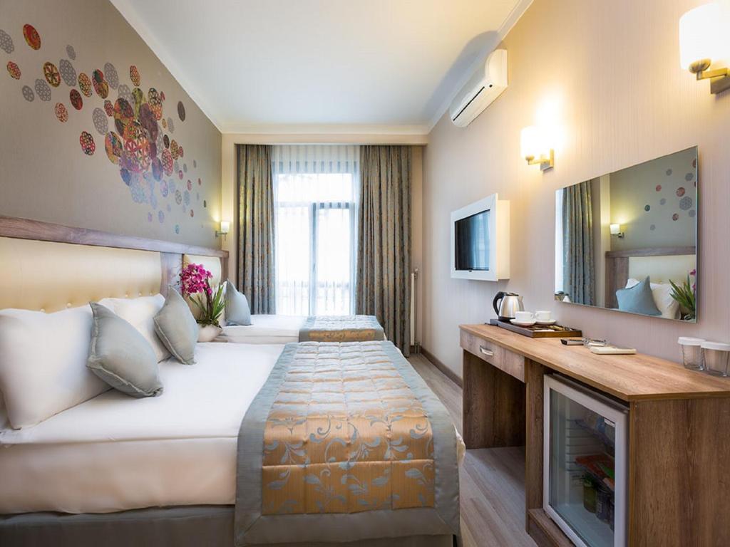 A hotel room with two beds , a desk and a television.