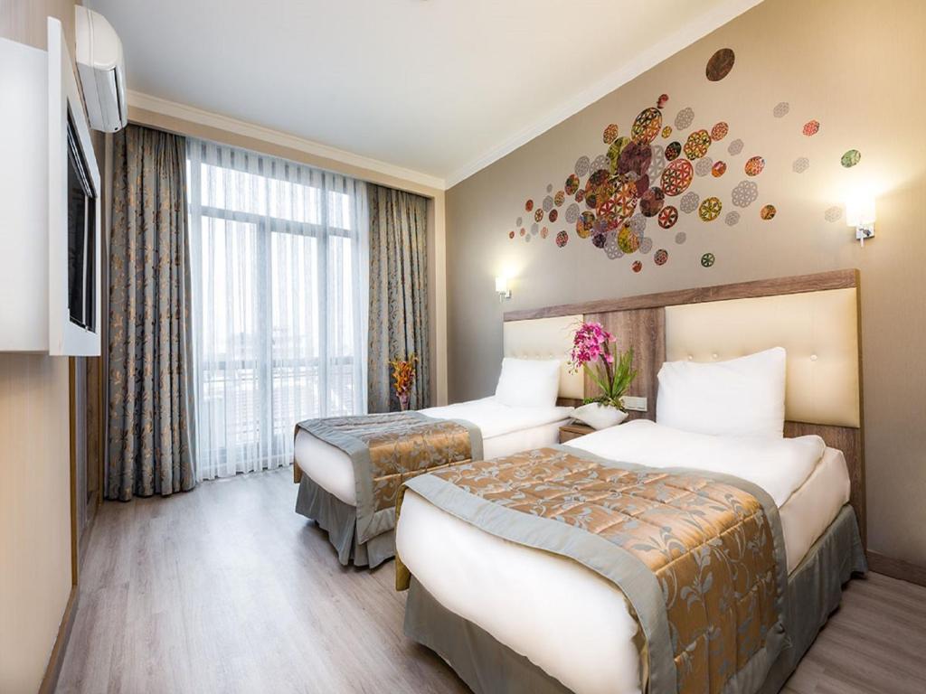 A hotel room with two beds and a television.
