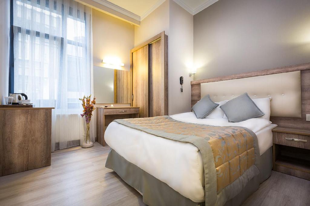 Fatih Hotel Corner, A hotel room with a large bed and a window.